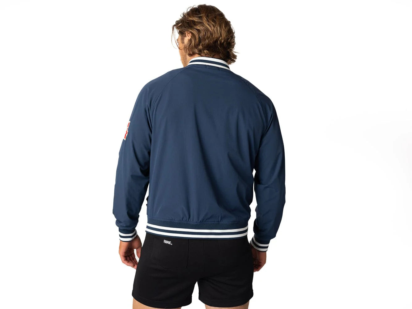 Blue vintage Varsity Bomber Jacket includes tackle twill "74" on the left sleeve, rib-knit collar and cuff, snap front closure, front hand pocket and interior chest pocket, and interior mesh lining.